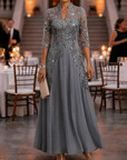 Champagnekleurige maxi-jurk van chiffon en mesh met gouden pailletten, bloemenprint en 3/4-mouwen