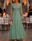 Champagnekleurige maxi-jurk van chiffon en mesh met gouden pailletten, bloemenprint en 3/4-mouwen