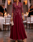 Champagnekleurige maxi-jurk van chiffon en mesh met gouden pailletten, bloemenprint en 3/4-mouwen